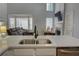 Kitchen featuring stainless steel sink and a view into the living room with many windows and natural light at 4149 Spring Cove Dr, Duluth, GA 30097
