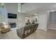 Bright open-concept living room with a fireplace, tall windows, and a kitchen view, creating a seamless living space at 4149 Spring Cove Dr, Duluth, GA 30097