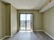 This bedroom features gray floors, neutral walls, and a sliding glass door to a private balcony with a neighborhood view at 795 Hammond Dr # 1108, Atlanta, GA 30328