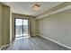 This bedroom features gray floors, neutral walls, and a sliding glass door to a private balcony with a neighborhood view at 795 Hammond Dr # 1108, Atlanta, GA 30328