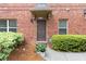 Brick townhouse with a covered front entrance, neat landscaping, and security system sign at 805 Pleasant Hill Nw Rd # 231, Lilburn, GA 30047