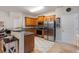 Modern kitchen with stainless steel appliances, wood cabinetry, and a breakfast bar area at 805 Pleasant Hill Nw Rd # 231, Lilburn, GA 30047