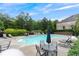 Community pool surrounded by mature landscaping, lounge chairs, and tables with umbrellas at 805 Pleasant Hill Nw Rd # 231, Lilburn, GA 30047