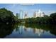 Scenic view of Piedmont Park's lake, reflecting the Atlanta skyline, surrounded by lush greenery, highlighting city living at 1230 Piedmont Ne Ave # 405, Atlanta, GA 30309