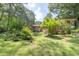Lush backyard featuring mature trees and well-maintained landscaping with access to a cozy back porch at 5400 Francis Ave, Stone Mountain, GA 30087