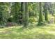 Lush backyard view with mature trees and a small shed, offering a serene and private outdoor space at 5400 Francis Ave, Stone Mountain, GA 30087
