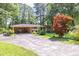 Quaint brick home featuring mature shade trees, covered carport, and long driveway at 5400 Francis Ave, Stone Mountain, GA 30087