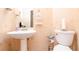 Cozy half bath with pedestal sink and neutral wallpaper at 4801 Deer Chase, Powder Springs, GA 30127