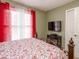 Comfortable bedroom featuring decoratively patterned bedding, an ornate headboard, and window at 4801 Deer Chase, Powder Springs, GA 30127