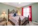 Relaxing bedroom featuring decoratively patterned bedding, an ornate headboard and warm paint at 4801 Deer Chase, Powder Springs, GA 30127
