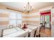 Elegant dining room with chandelier, striped walls, and sliding door at 4801 Deer Chase, Powder Springs, GA 30127