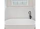Bright bathroom featuring a window above a white soaking tub with black fixtures at 1010 Fendley St, Woodstock, GA 30188