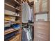 Walk-in closet with custom dark wood cabinetry, multiple shelves, drawers and hanging racks at 1010 Fendley St, Woodstock, GA 30188