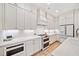 Bright kitchen features white cabinets, quartz countertops, and stainless steel appliances at 1010 Fendley St, Woodstock, GA 30188