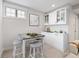 Charming kitchenette featuring white cabinetry, marble countertops, and a stylish dining table at 1010 Fendley St, Woodstock, GA 30188