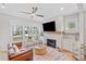 Bright living room with fireplace, ceiling fan, modern decor, and large windows at 1010 Fendley St, Woodstock, GA 30188