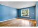 Bedroom featuring hardwood floors, blue walls, white trim and a window overlooking a covered porch at 3185 Oak Ridge Ln, Loganville, GA 30052