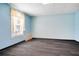 Bedroom featuring light blue walls, a window with blinds, and gray plank flooring at 3185 Oak Ridge Ln, Loganville, GA 30052