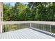 Relax on this spacious deck with white railings, offering a peaceful view of the lush, green backyard at 3185 Oak Ridge Ln, Loganville, GA 30052