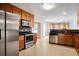 Kitchen features stainless steel appliances, wood cabinets, black countertops and tile flooring at 3185 Oak Ridge Ln, Loganville, GA 30052