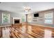 Spacious living room featuring hardwood floors, a brick fireplace, and plenty of natural light at 3185 Oak Ridge Ln, Loganville, GA 30052