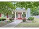 Inviting front porch with elegant white columns and double red doors surrounded by manicured landscaping at 330 Bay Grove Rd, Loganville, GA 30052