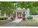 Inviting front porch with elegant white columns and double red doors surrounded by manicured landscaping at 330 Bay Grove Rd, Loganville, GA 30052