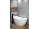 Modern bathroom with freestanding tub, sleek black faucet, and gray tiled wall at 3421 Fawn Trl, Marietta, GA 30066
