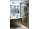 Well-lit bathroom showcases a double vanity, modern mirror, and glass-enclosed shower with wood accents at 3421 Fawn Trl, Marietta, GA 30066