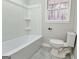 Bright bathroom featuring a shower-tub combination and white toilet, with natural light from a window at 3421 Fawn Trl, Marietta, GA 30066