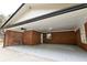 Covered parking area featuring red brick, exposed ceiling, and concrete floor at 3421 Fawn Trl, Marietta, GA 30066
