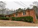Brick house featuring long porch, wood shutters, and manicured green hedges at 3421 Fawn Trl, Marietta, GA 30066