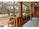 Covered porch with modern wood railing, showcasing a tranquil view of the front yard at 3421 Fawn Trl, Marietta, GA 30066