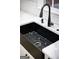 Close-up of a black farmhouse sink with white countertops and subway tile backsplash, adding character to the kitchen at 3421 Fawn Trl, Marietta, GA 30066