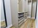 Spacious walk-in closet with custom shelving and drawers, wood floor, and mirror at 3421 Fawn Trl, Marietta, GA 30066