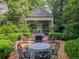 Charming brick patio with outdoor seating and lush landscaping at 240 Nacoochee Nw Dr, Atlanta, GA 30305