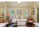 Bright bathroom featuring a soaking tub, round windows, and antique-style chairs at 240 Nacoochee Nw Dr, Atlanta, GA 30305
