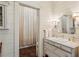 Well-lit bathroom with a vanity and sink, plus a curtained shower stall and wood paneled walls at 240 Nacoochee Nw Dr, Atlanta, GA 30305