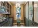 Elegant butler's pantry with ample storage, glass cabinets, and a view to the outside at 240 Nacoochee Nw Dr, Atlanta, GA 30305
