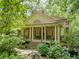 Charming home exterior with stone columns, lush landscaping, and a welcoming front porch creating inviting curb appeal at 240 Nacoochee Nw Dr, Atlanta, GA 30305