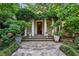 Inviting front entrance with stone walkway, lush greenery, and covered porch with pillars at 240 Nacoochee Nw Dr, Atlanta, GA 30305