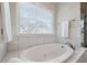 Inviting bathroom with a soaking tub and a window with natural light at 310 Medridge Dr, Alpharetta, GA 30022