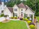Beautiful two-story home with lush landscaping, a well-manicured lawn, and an attached two-car garage at 310 Medridge Dr, Alpharetta, GA 30022