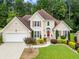 Charming two-story home featuring manicured landscaping and a welcoming red front door at 310 Medridge Dr, Alpharetta, GA 30022