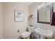 Stylish powder room features a pedestal sink, framed mirror, and decorative Williamsburg print at 310 Medridge Dr, Alpharetta, GA 30022