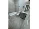 Clean, remodeled bathroom with gray tile flooring, new fixtures, and a bathtub at 1340 Stoneleigh Way, Stone Mountain, GA 30088