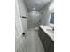 Stylish bathroom with a new glass shower door, gray vanity and modern tile at 1340 Stoneleigh Way, Stone Mountain, GA 30088