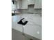 Bright kitchen island featuring white quartz countertops and a sleek, built-in pop-up power outlet at 1340 Stoneleigh Way, Stone Mountain, GA 30088