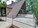 Wooden deck showcasing railings with a view of the A-frame style house, surrounded by greenery at 1467 Shiloh Trail East Nw, Kennesaw, GA 30144