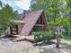 Exterior of A-frame home featuring a wooden deck and large windows, surrounded by lush greenery at 1467 Shiloh Trail East Nw, Kennesaw, GA 30144